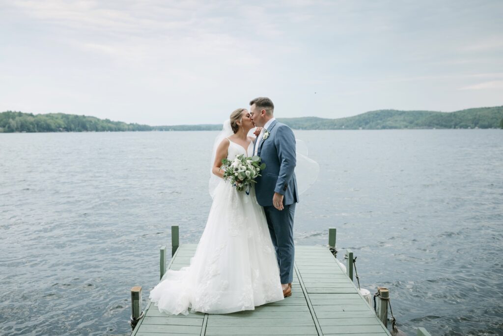 couple kissing on the dock at the lake bomoseen lodge, vermont wedding venues 