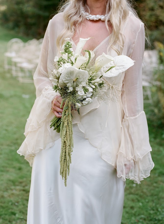 An anthurium bridal bouquet with white blooms and green hanging amaranthus. 