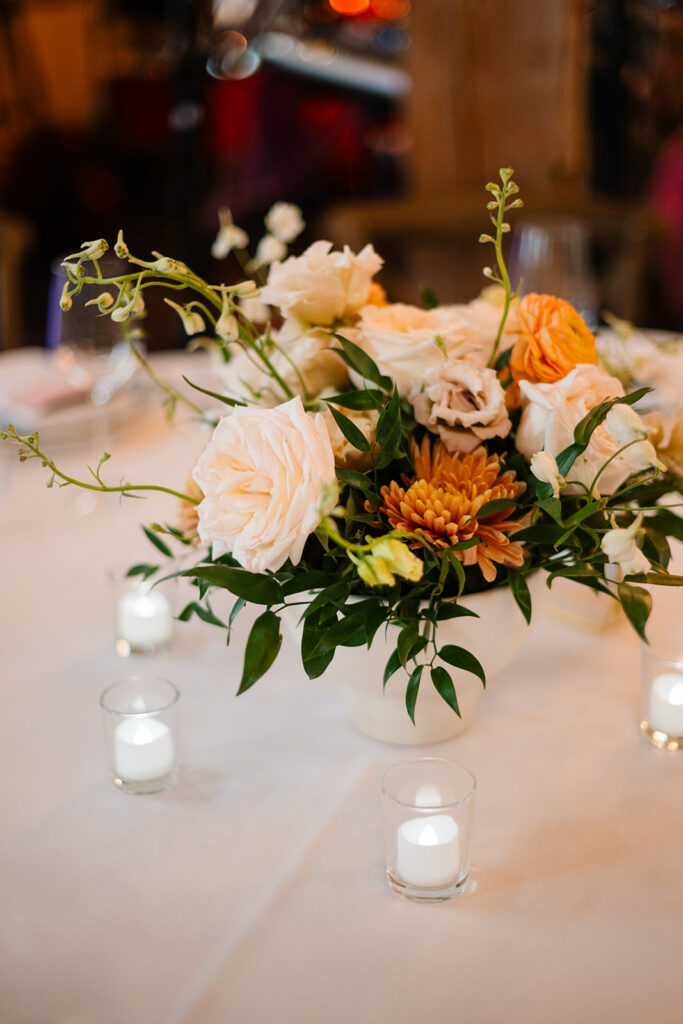 Blush, orange and yellow round table centerpiece. 