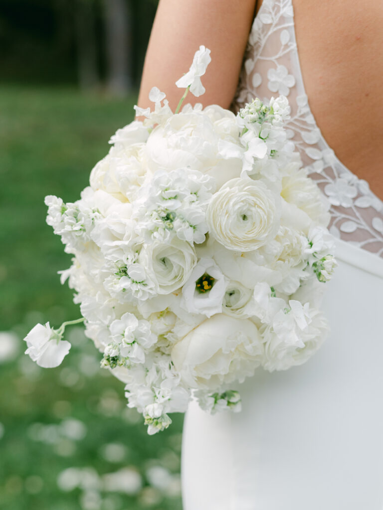 Bridal bouquet close up shot featuring ranunculus, sweetpeas, stock, and peonies. 